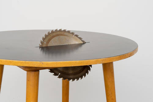 table qui se fait découper par le disque d'une scie circulaire